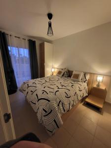 a bedroom with a bed with a black and white comforter at El Soleado El Rincon in Campoamor +65 photos