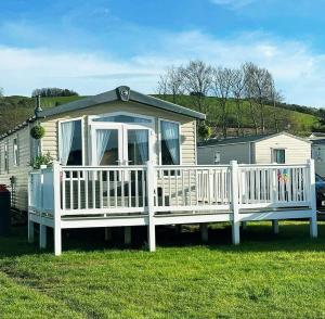 沃切特Spacious and modern 3 bedroom Doniford Bay Haven Caravan Park Static Caravan的白色门廊和白色围栏的房子