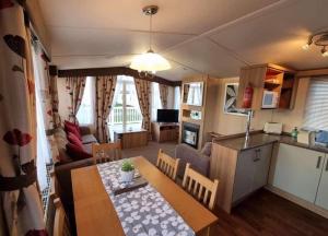沃切特Spacious and modern 3 bedroom Doniford Bay Haven Caravan Park Static Caravan的厨房以及带餐桌的起居室。