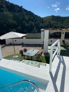 taras ze stołem, krzesłami i parasolem w obiekcie Villa Jardin piscina climatizada w mieście Frigiliana +19 zdjęć