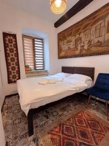 ein Schlafzimmer mit einem großen Bett und einem blauen Stuhl in der Unterkunft Luky 12 in Braşov