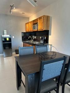 une cuisine avec une table en bois et des chaises bleues dans l'établissement Loft privado cerca del Jardín Principal de Sayula, à Sayula 9 autres photos