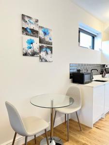 a white kitchen with a table and chairs at luxury apartment in East London in London