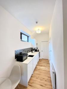 a white kitchen with a sink and a counter at luxury apartment in East London in London