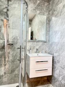 a bathroom with a white sink and a shower at luxury apartment in East London in London