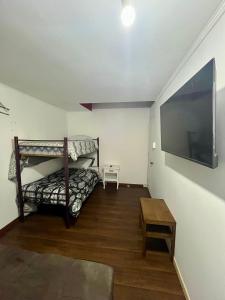 圣地亚哥Hostel Tu Espacio RE - Habitaciones cerca del Aeropuerto的一间卧室配有两张双层床和一台平面电视