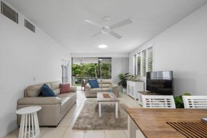 un salon avec un canapé et une télévision dans l'établissement Pool View 3-Bedroom Oasis in Drift Resort, à Casuarina