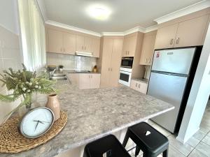 a kitchen with a counter with a clock on it at Saile in Evans Head +9 photos