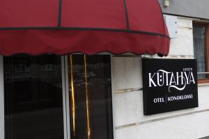 una tienda con toldo rojo y un cartel en un edificio en Kütahya Şehir Otel, en Kütahya