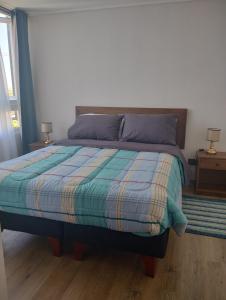 uma cama num quarto com duas lâmpadas nas mesas em Precioso y confortable Departamento em Santiago mais 11 fotografias
