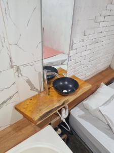 un bagno con una ciotola nera su un tavolo di legno di Quarto casal banheira a Conde