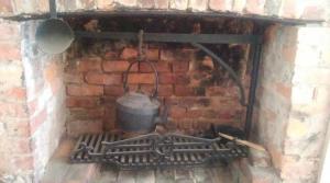 a large pot on top of a brick fireplace at Woiworung Cottage-BYO bed linen and towels-NO WIFI, NO TV take a step back in time, escape from technology and recharge in Gisborne