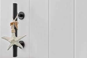 une étoile de mer suspendue sur un mur dans l'établissement Waves Retreat - Coastal Style Home near Warana Beach, à Parrearra