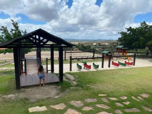 a little girl is standing in a playground at Flat em Gravatá - Fazenda Monte Castelo - quarto superior com Wi-Fi e netflix in Gravatá