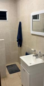 Un baño con lavabo y ducha con espejo. en El Buen Vivir, en Mar del Plata 8 fotos más