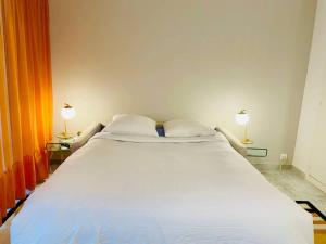 a large white bed in a room with two lamps at Studio in Antibes near La Salis Beach in Antibes