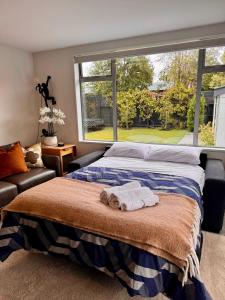 a bedroom with a bed and a large window at Private Family City Retreat, Sleeps 8 in Christchurch