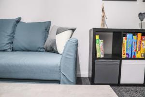 un canapé bleu dans un salon avec une étagère à livres dans l'établissement 3Bedroom EnSuite SofaBed Sleeps upto 6 Contractors Families Long or Short Stay Free Parking WIFI, à Ashington