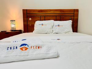 ein Bett mit weißen Laken und Kissen darauf in der Unterkunft Habitación Céntrica en Iquitos - Casa Alemi 17 in Iquitos + 1 Foto