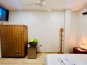 ein Schlafzimmer mit einem Bett und einem Holzschrank in der Unterkunft Habitación Céntrica en Iquitos - Casa Alemi 17 in Iquitos