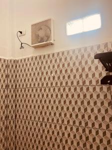 a bathroom with a shower with a radiator and a window at The Homey Coliving Lhokseumawe in Hago