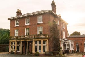an old red brick building with a porch at Aylestone Court in Hereford
