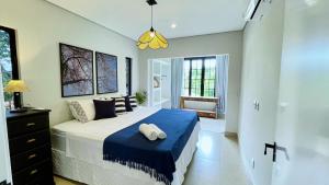 a bedroom with a large bed with a blue blanket at Casa Paraíso in Pirenópolis +16 photos