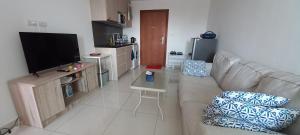 a living room with a couch and a flat screen tv at Paradise Now in Jomtien Beach