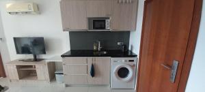 a kitchen with a washing machine and a microwave at Paradise Now in Jomtien Beach