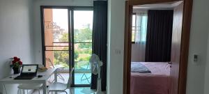 a room with a bed and a desk with a laptop at Paradise Now in Jomtien Beach