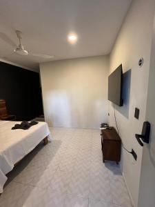 Un dormitorio con una cama y un televisor de pantalla plana. en Hotel Ha Garden Gallery - 5th Avenue, en Playa del Carmen