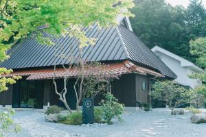 a building with a roof with a sign in front of it at hitaru Ishibashi-tei in Ōasa