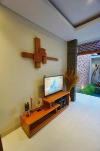 a living room with a flat screen tv on a wall at Happy Nest Canggu in Tumbak Bayuh +8 photos