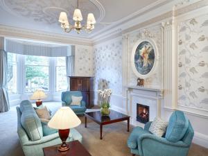 a living room with blue chairs and a fireplace at Hapimag Resort Edinburgh in Edinburgh