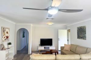 a living room with a couch and a ceiling fan at Pet Friendly home in Maroochydore in Maroochydore