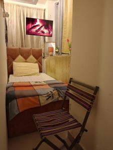 迪拜Private Partition room的一间带床、椅子和电视的卧室