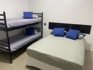 a bedroom with two bunk beds with blue pillows at Casa na praia em Torres my house in Torres in Torres