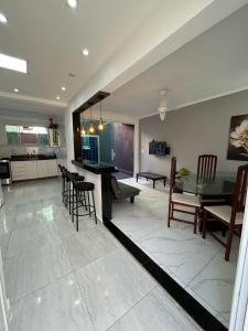 a dining room and living room with a table and chairs at Casa Ferry Piscina Privativa e Hidro 300m da Praia in Praia Grande