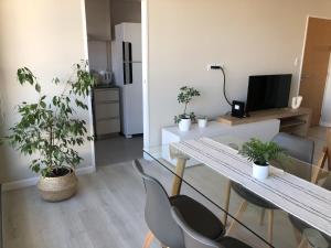 a living room with a table and chairs with plants at Departamento JACARANDA con cochera in Bahía Blanca +23 photos