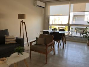 a living room with a couch and a table with chairs at Departamento JACARANDA con cochera in Bahía Blanca