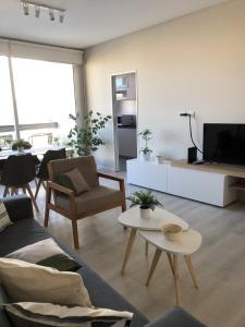 a living room with a couch and a tv at Departamento JACARANDA con cochera in Bahía Blanca