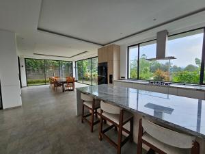 a kitchen with a large counter with chairs and a table at Villa W Trinity in Batureo 1