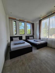 two beds in a room with windows at Villa W Trinity in Batureo 1 +25 photos