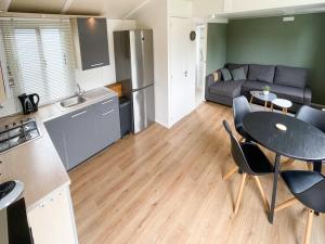 a kitchen and a living room with a table and chairs at Chalet in Friesland near Wadden Sea in Tzummarum