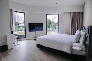 una camera d'albergo con un grande letto e una TV di Page148, Page Hotels a Hong Kong