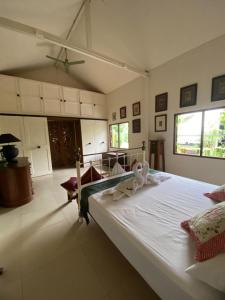 a bedroom with a large white bed with towels on it at Mintys Folly 2 in Ban Man