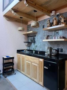 eine Küche mit einem schwarzen Kühlschrank und einem schwarzen Geschirrspüler in der Unterkunft Casa Coco H3 Luna in San Cristóbal de las Casas