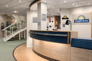 a day inn lobby with a counter and stairs at Days Inn by Wyndham Donington in Castle Donington