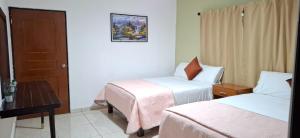 ein Hotelzimmer mit zwei Betten und einem Tisch in der Unterkunft El Ausente in Ciudad Valles