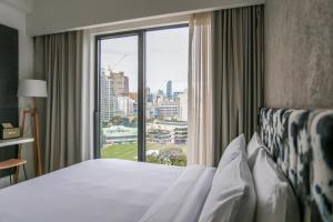 ein Hotelzimmer mit einem Bett und einem großen Fenster in der Unterkunft Page148, Page Hotels in Hongkong
